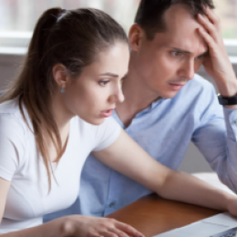 frustrated couple in front of computer