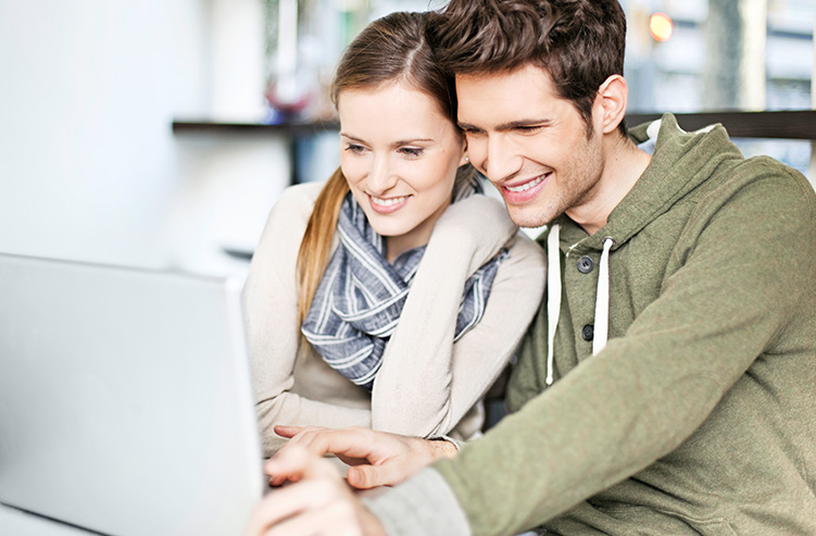 excited couple in front of computer